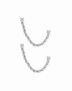 close up of silver earrings with double piercing diamond tennis chain.