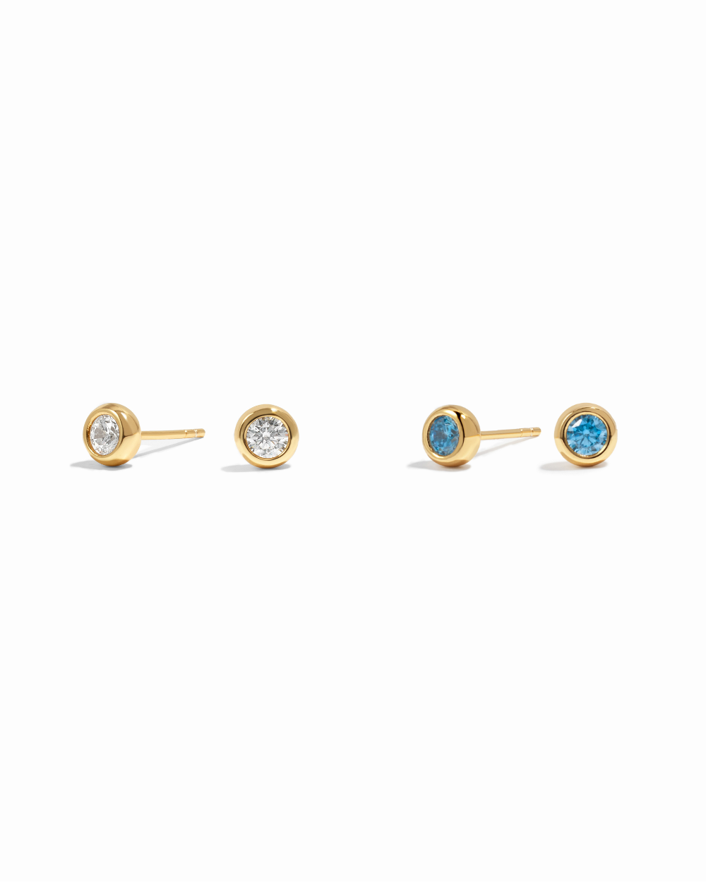 Pair of gold stud earrings with gemstones on a white background