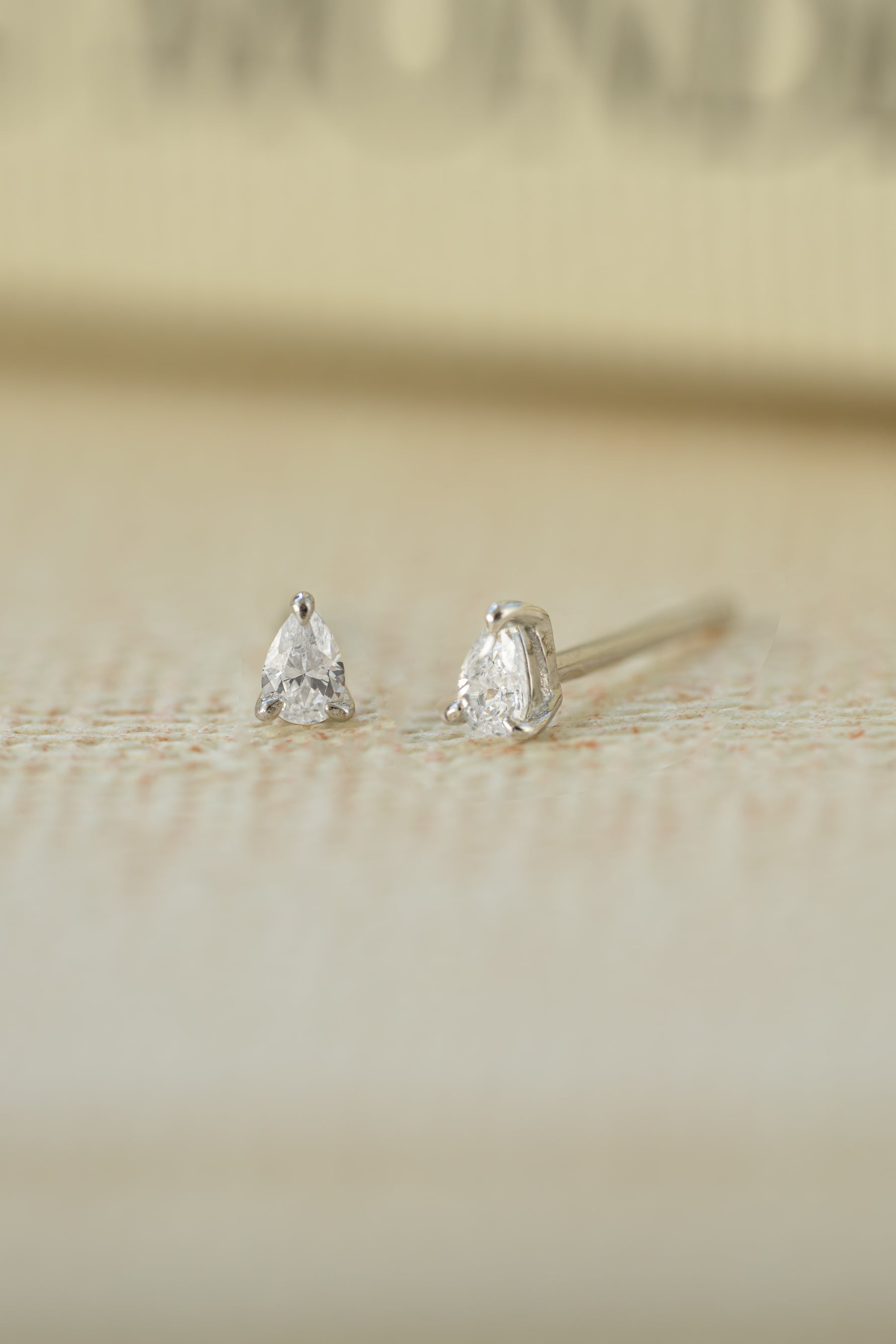 Sterling silver bridal jewelry featuring silver studs on a blurred background