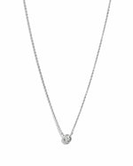 Silver necklace with a small round bezel set diamond pendant on a white background