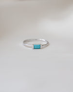 sterling silver baguette gemstone ring with a turquoise stone on a light gray background