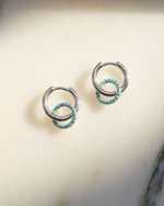 Pair of sterling silver drop earrings with turquoise stones on a light background