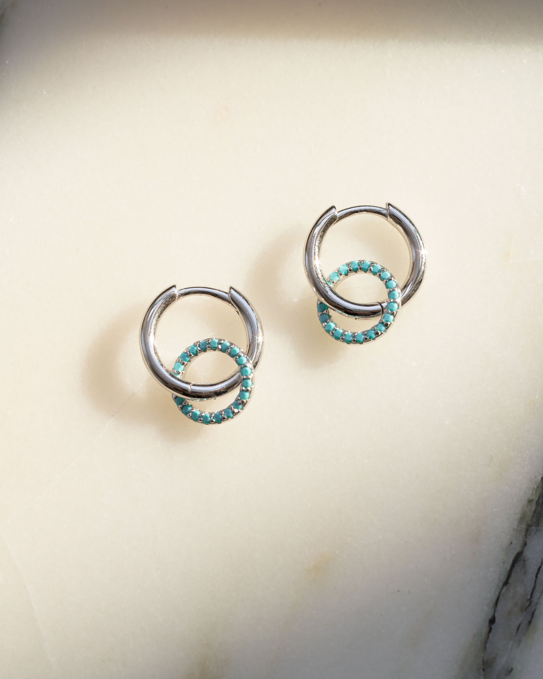 Pair of sterling silver drop earrings with turquoise stones on a light background