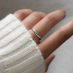 Model wearing a dainty ring  in silver that feels like a gentle hug around the finger.