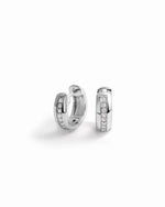 close up of minimalist silver diamond huggies showing intricate detailing. 