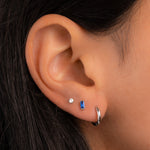 model wearing silver earrings including sapphire earrings