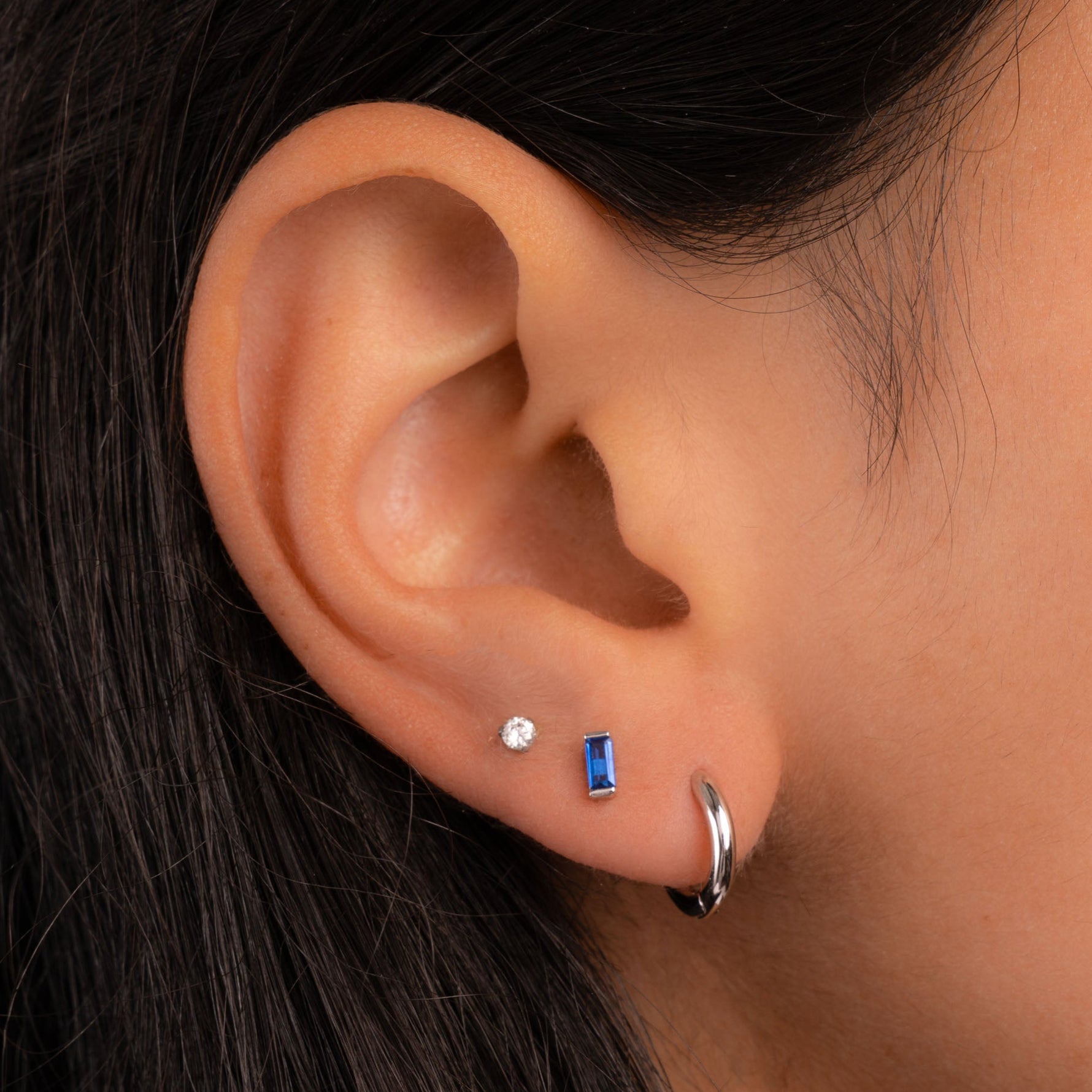 model wearing silver earrings including sapphire earrings