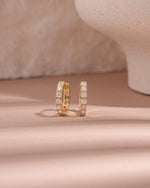closeup image of gold hoop earrings with cubic zirconia studs 