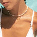 Model wearing pearl necklace stack bundle, pearl beaded necklace, paperclip necklace, and pearl pendant necklace, wearing in the pool.