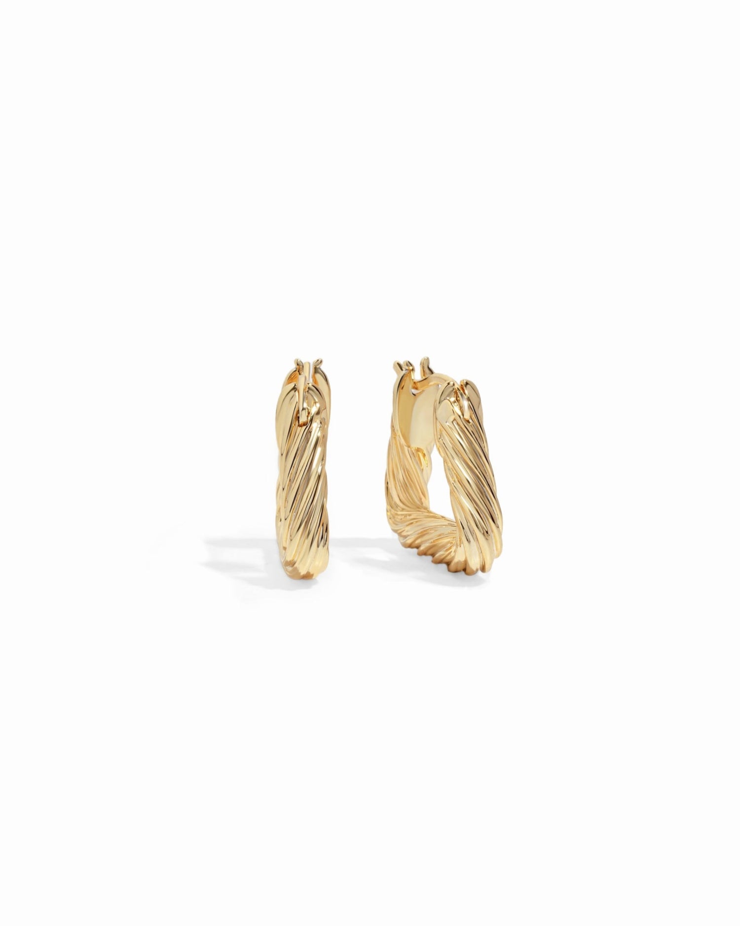 Side and front profile of chunky gold hoop earrings with a geometric design.