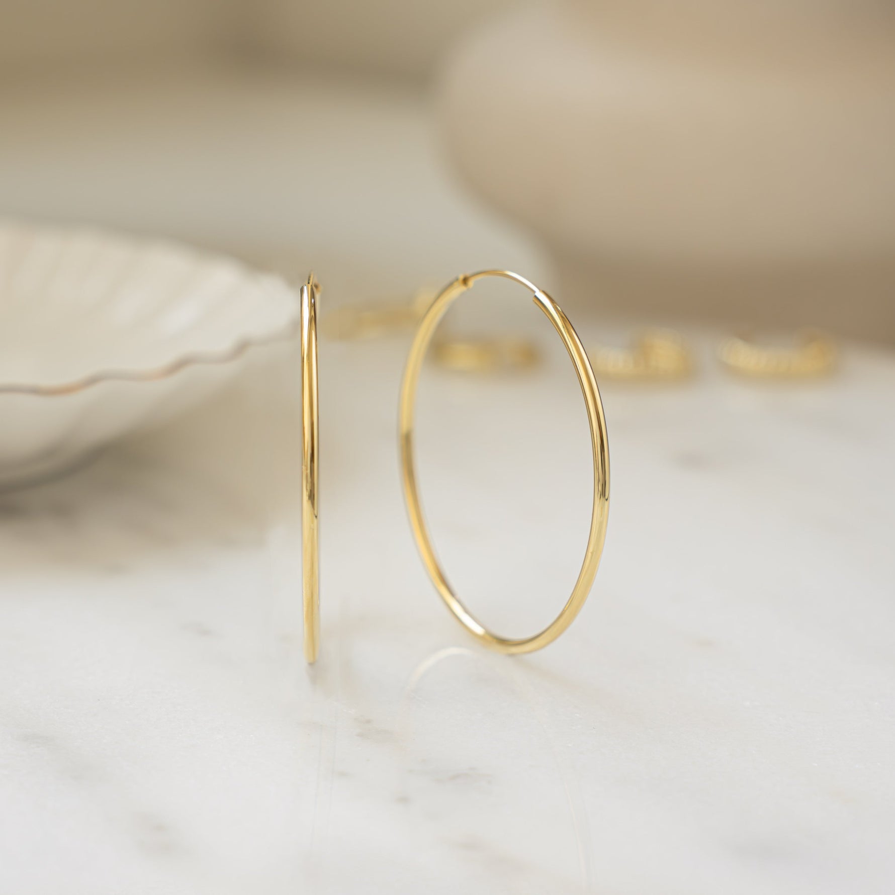 closeup image of skinny gold hoop earrings