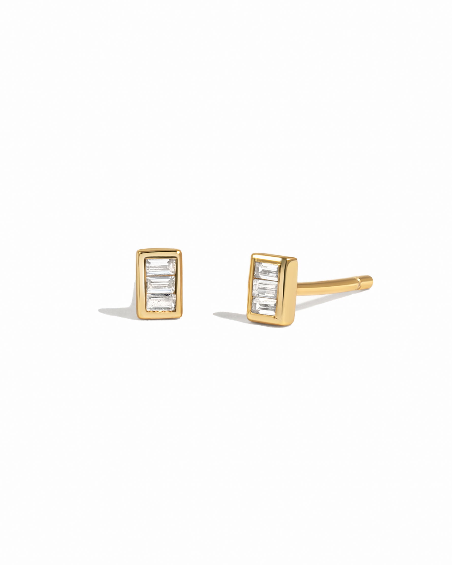 Gold baguette stud earrings on a white background