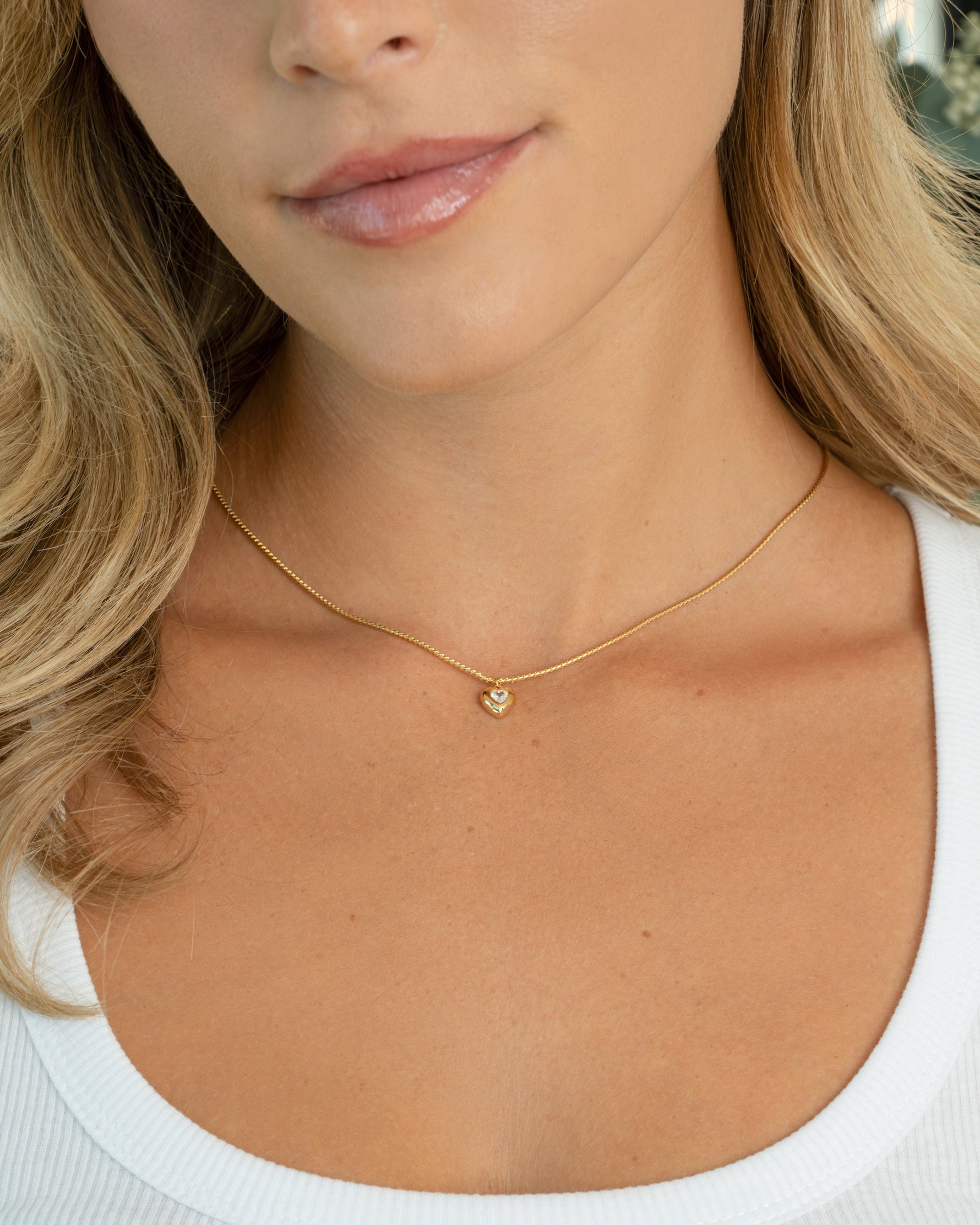 Model wearing gold love necklace