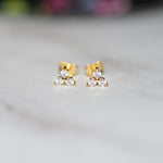 closeup image of gold three stone cluster stud earrings