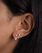 Gold drop earrings and diamond stud earrings on model