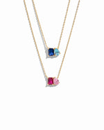 Two gold necklaces with custom birthstone gemstone pendants on a white background, 