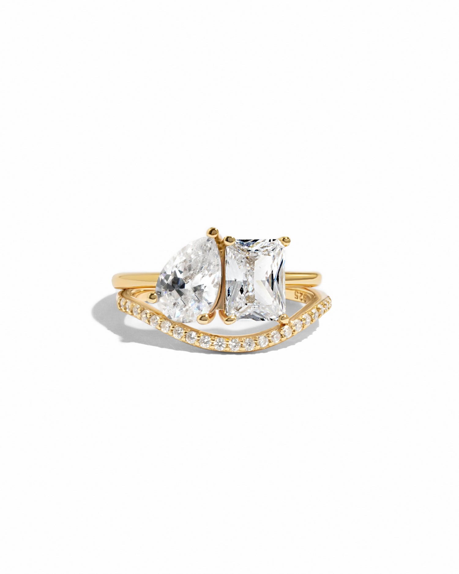 Toi Et moi matching band set, featuring, a pear-cut and emerald cut stone on a gold band, with a matching pave curved gold band on a white background