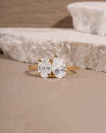 Gold promise ring on a beige surface