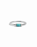 Sterling silver ring with a turquoise baguette gemstone with tiny diamond accents on a white background