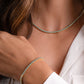 Close-up of a person wearing a matching gold turquoise tennis bracelet and turquoise bezel set tennis necklace