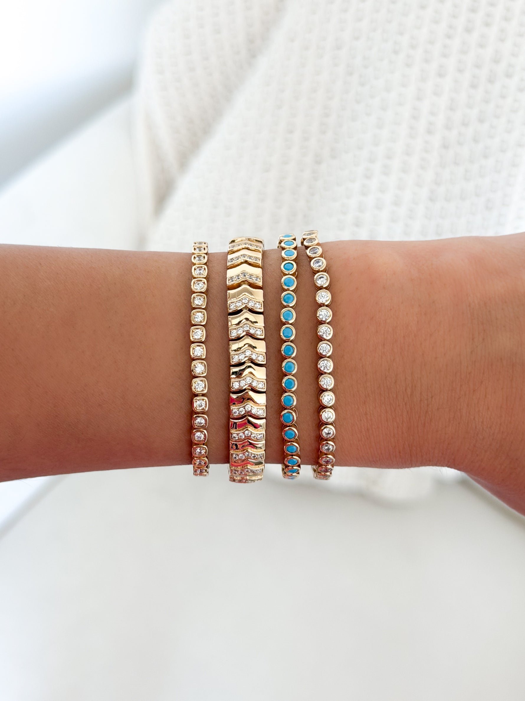 Turquoise bezel tennis bracelet by Sami Jewels featuring a row of turquoise stones set in a sleek metal bracelet.