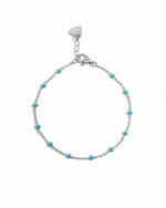 Silver bracelet with turquoise beads on a white background