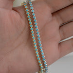 models hand showcasing gold and silver bezel set turquoise tennis bracelet
