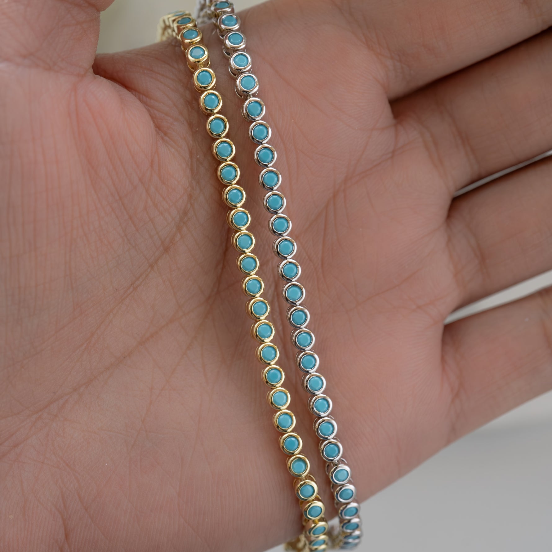 models hand showcasing gold and silver bezel set turquoise tennis bracelet