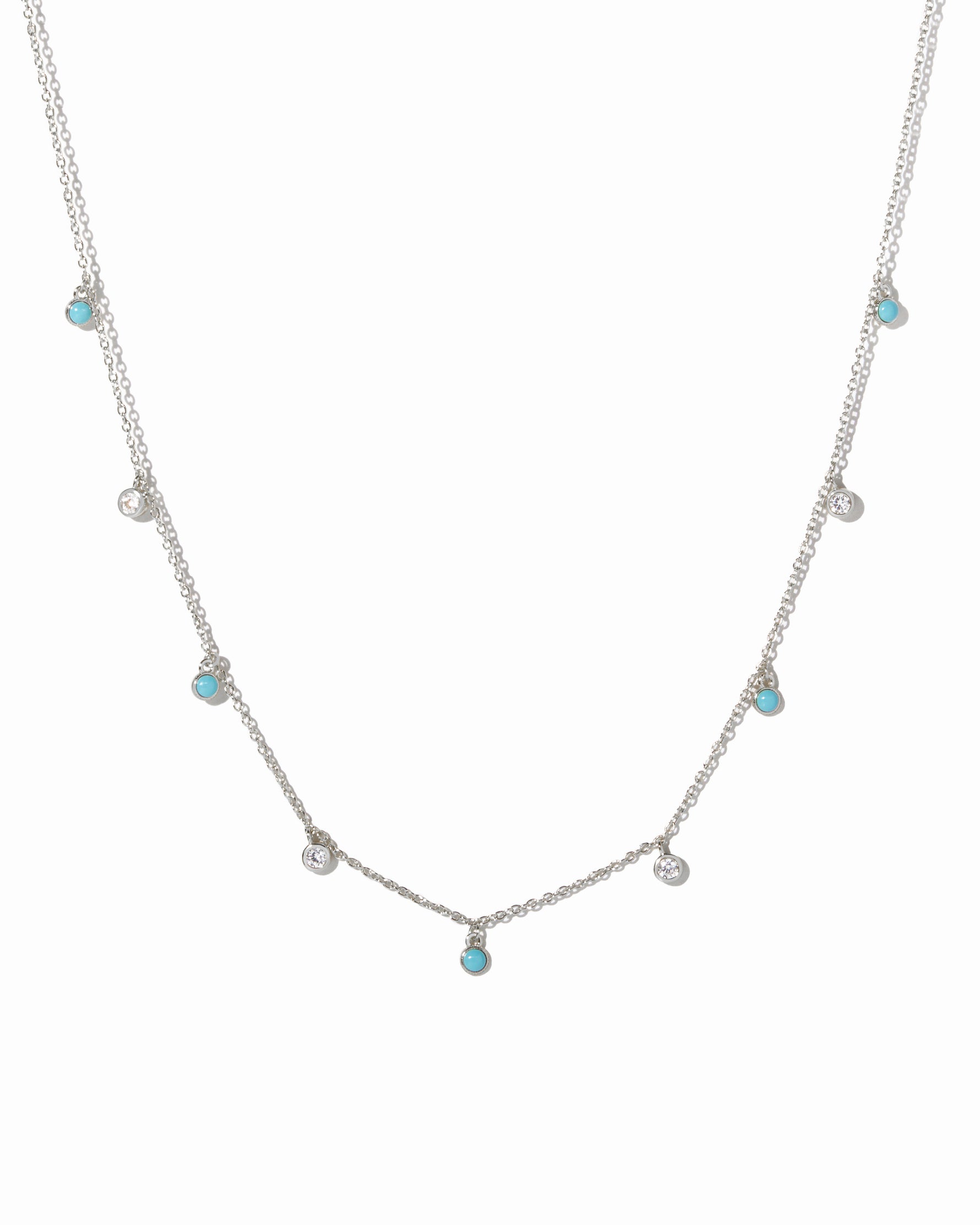 sterling silver necklace with small turquoise and cubic zirconia gemstones on a white background