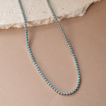 closeup image of turquoise jewelry featuring a dainty silver tennis necklace