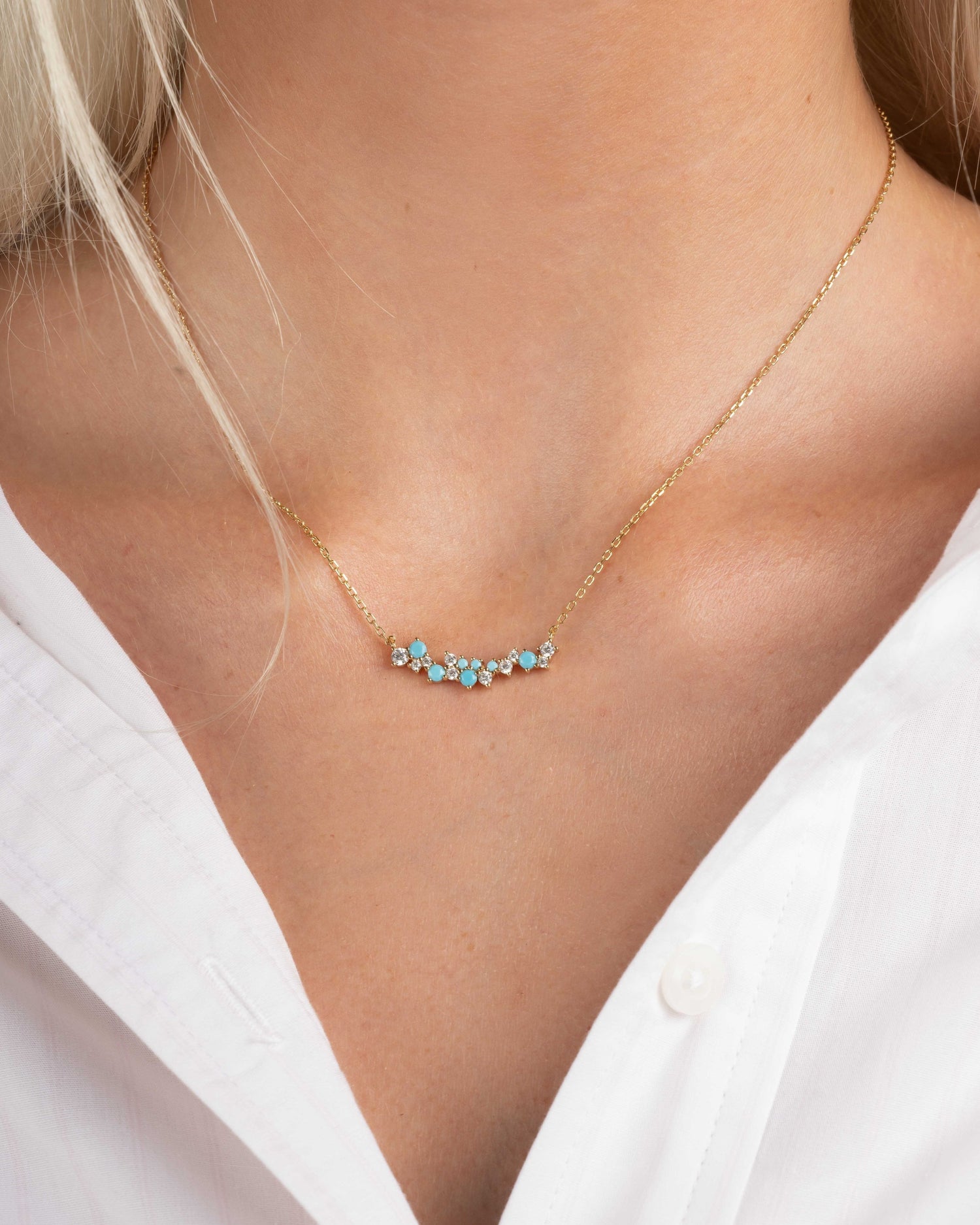 model wearing gold bar necklace with a turquoise and cubic zirconia beaded necklace design 