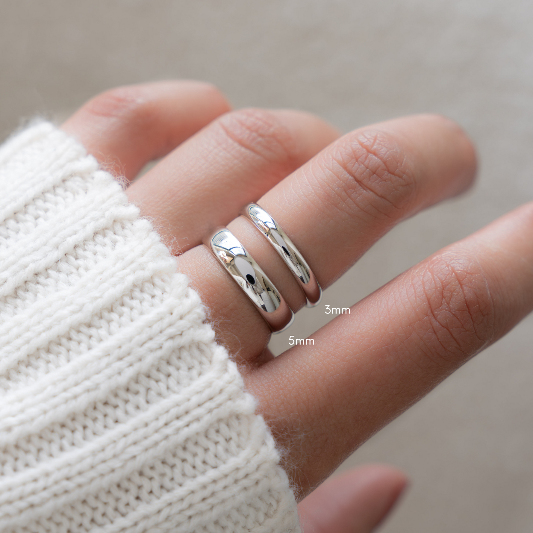 model wearing dainty rings and showing comparison of thin and thick silver rings for stacking inspiration.