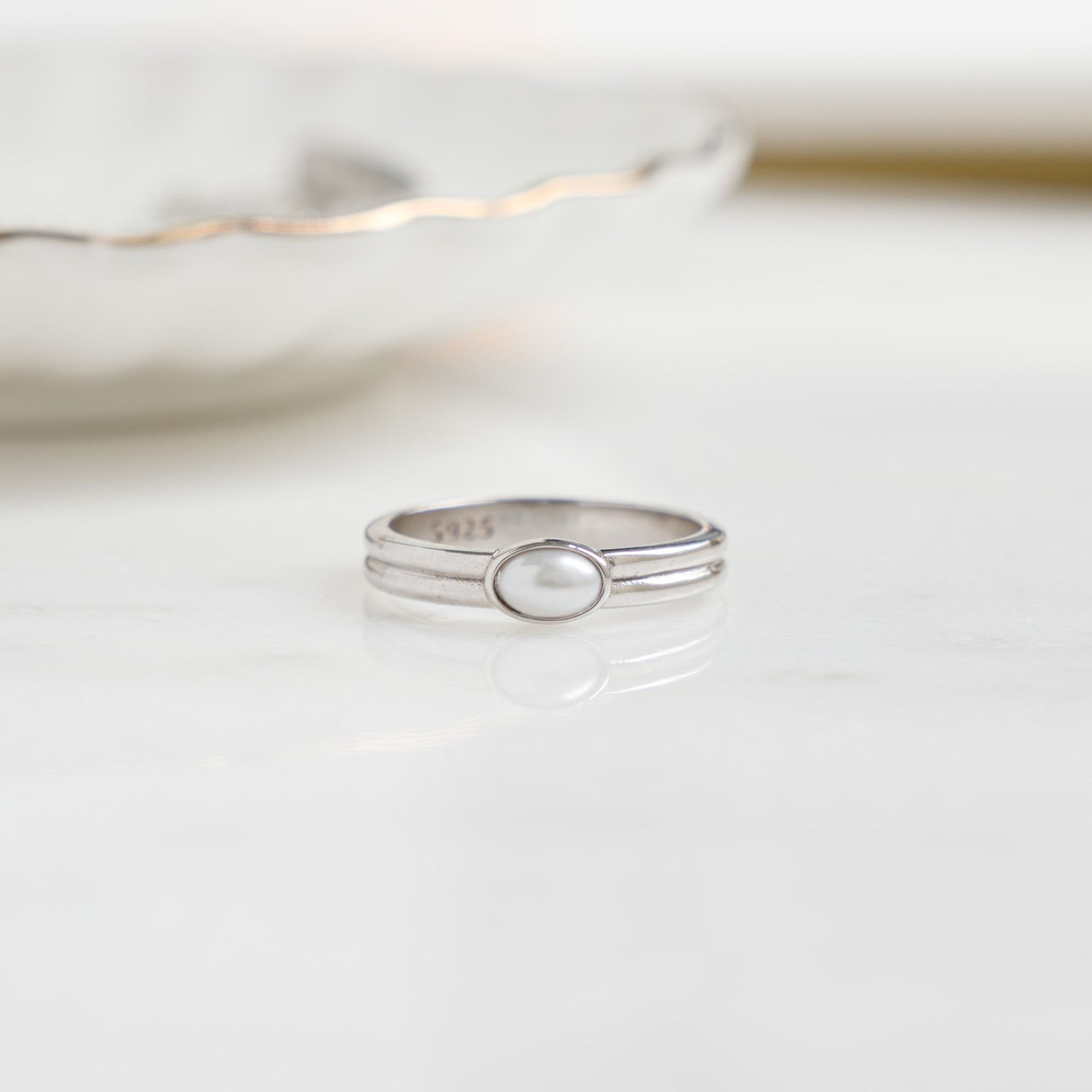 closeup image of silver vintage ring with an oval pearl 