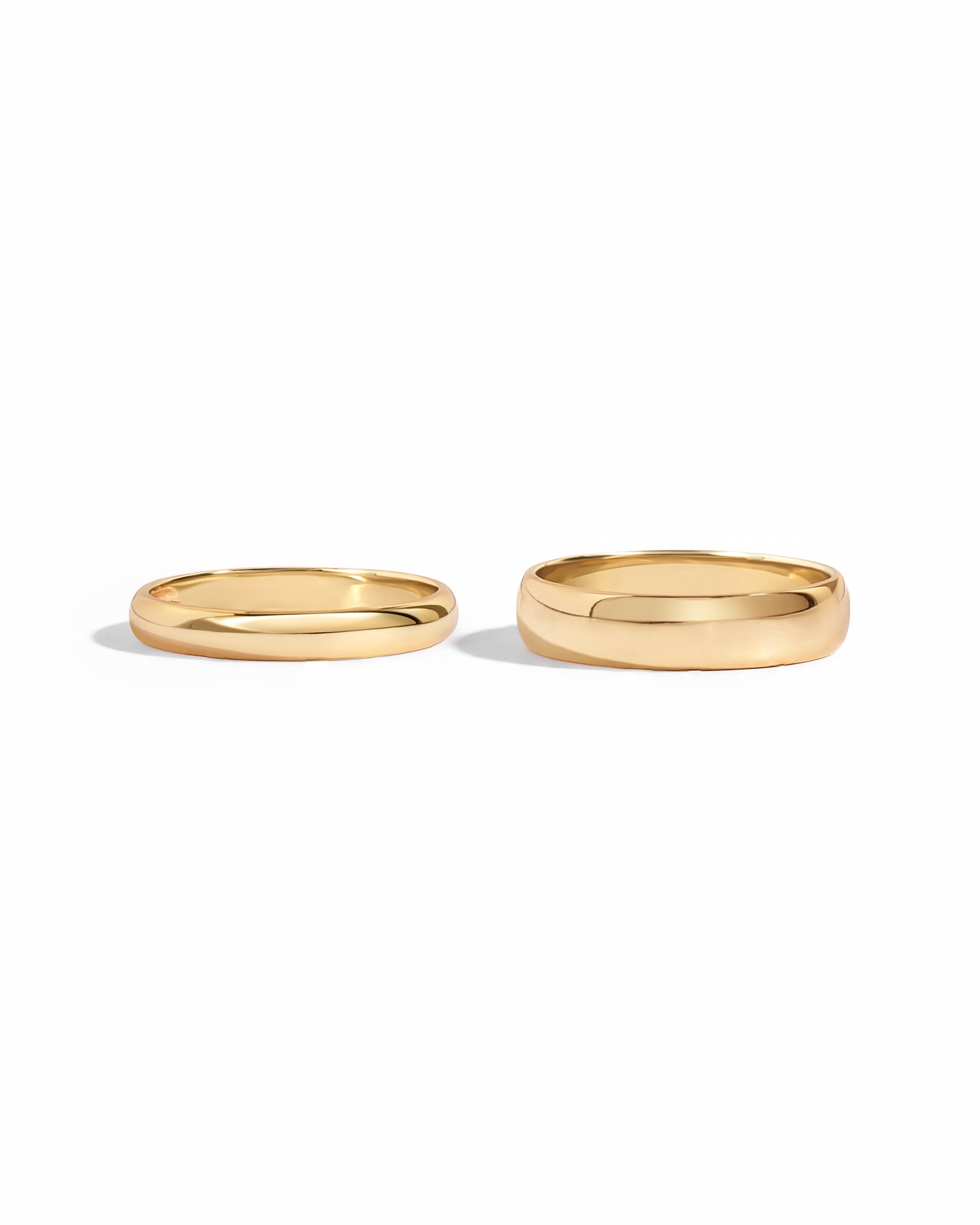 closeup image of 2 gold stacking rings, one 3mm band, and one 5mm band