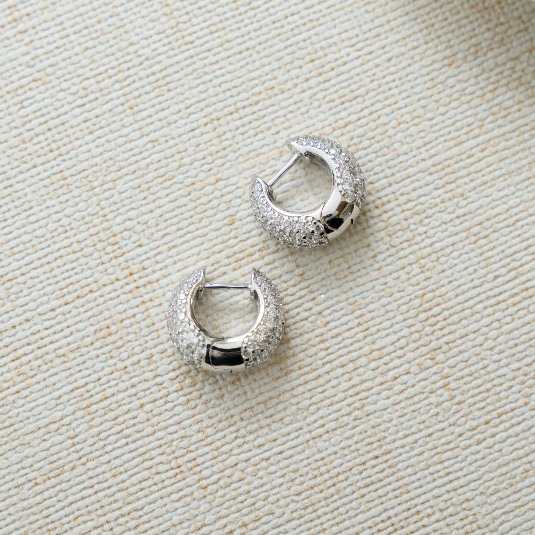 closeup image of silver hoops with chunky hoop design and cubic zirconia diamonds 
