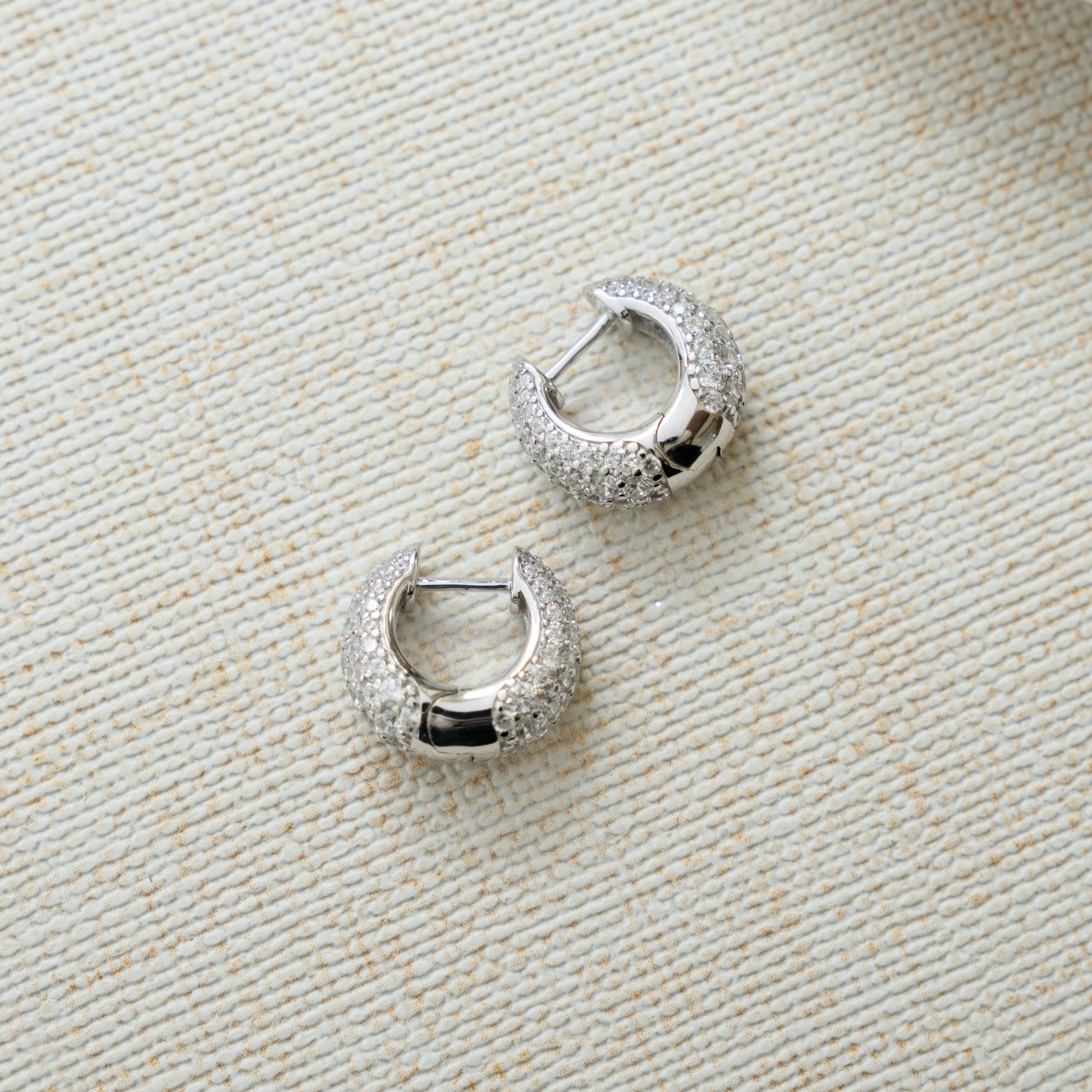 closeup image of silver hoops with chunky hoop design and cubic zirconia diamonds 