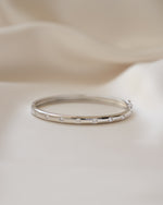 Sterling silver bridal jewelry featuring a silver bangle, with cubic zirconia diamonds