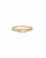 Gold ring with a bagutte-cut diamond on a white background