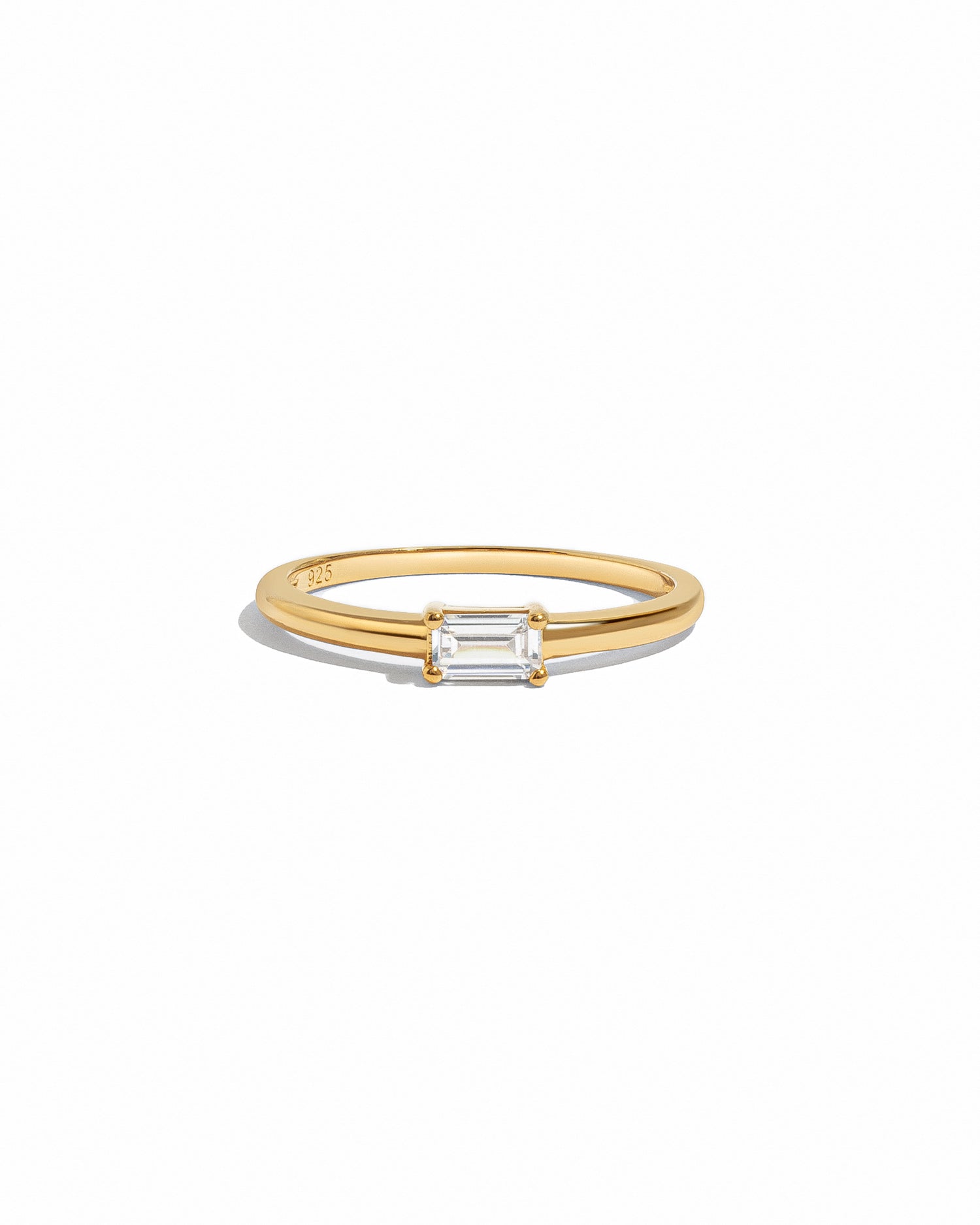 Gold ring with a bagutte-cut diamond on a white background