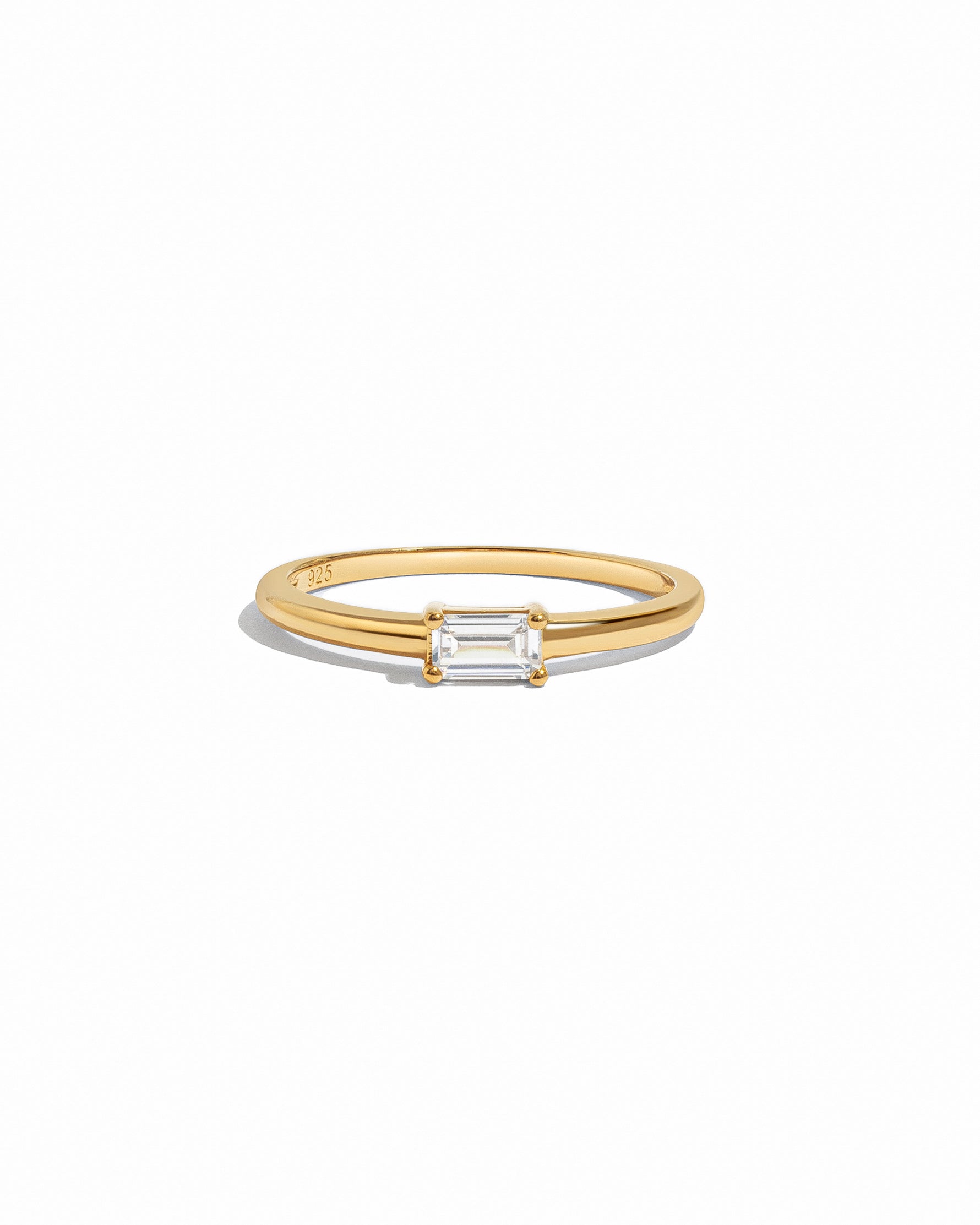 Gold ring with a bagutte-cut diamond on a white background