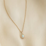 Closeup image of opal necklace with dainty diamonds and 14k gold plating