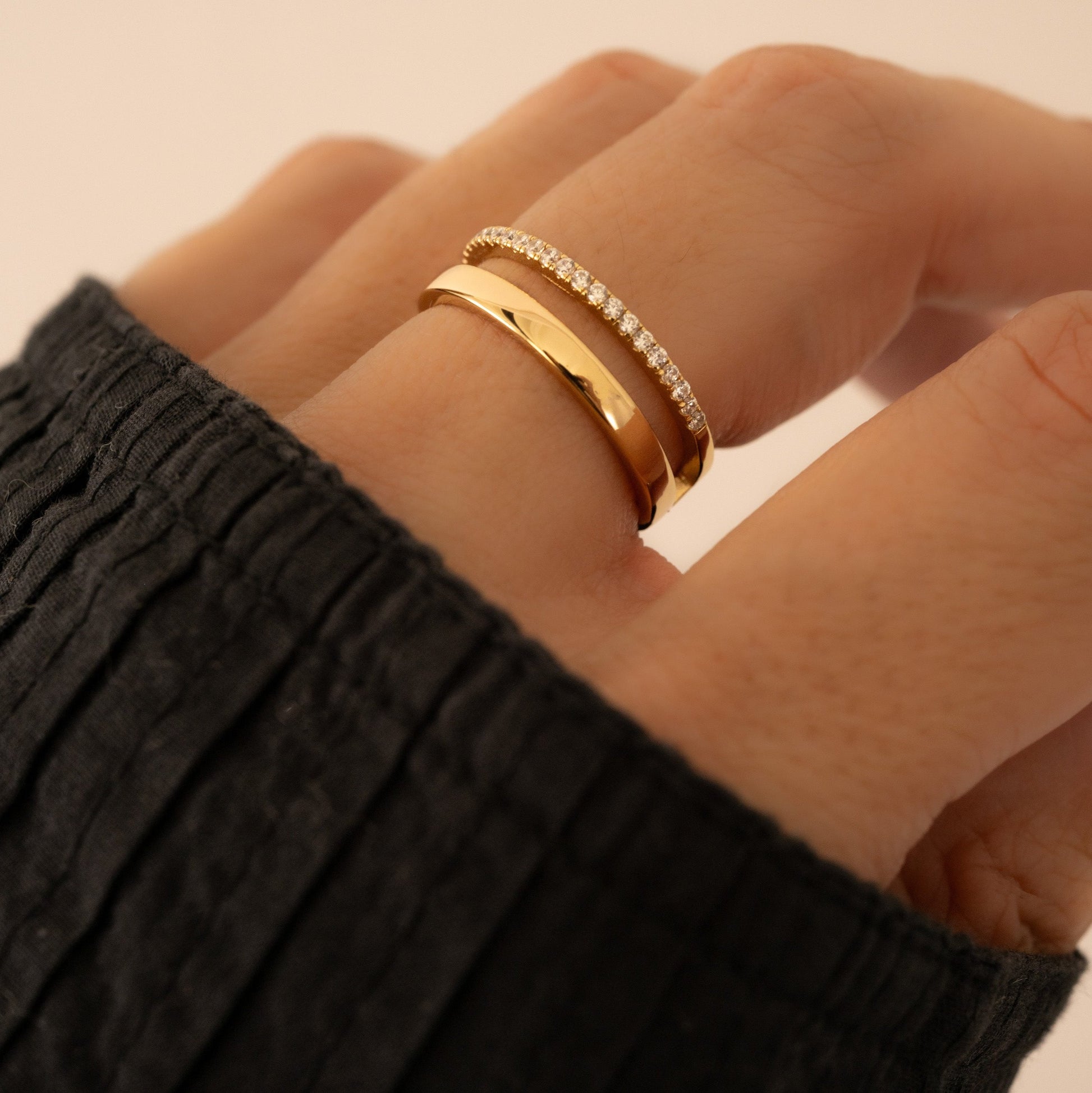 Closeup of gold double band ring with tiny diamonds on models's hand