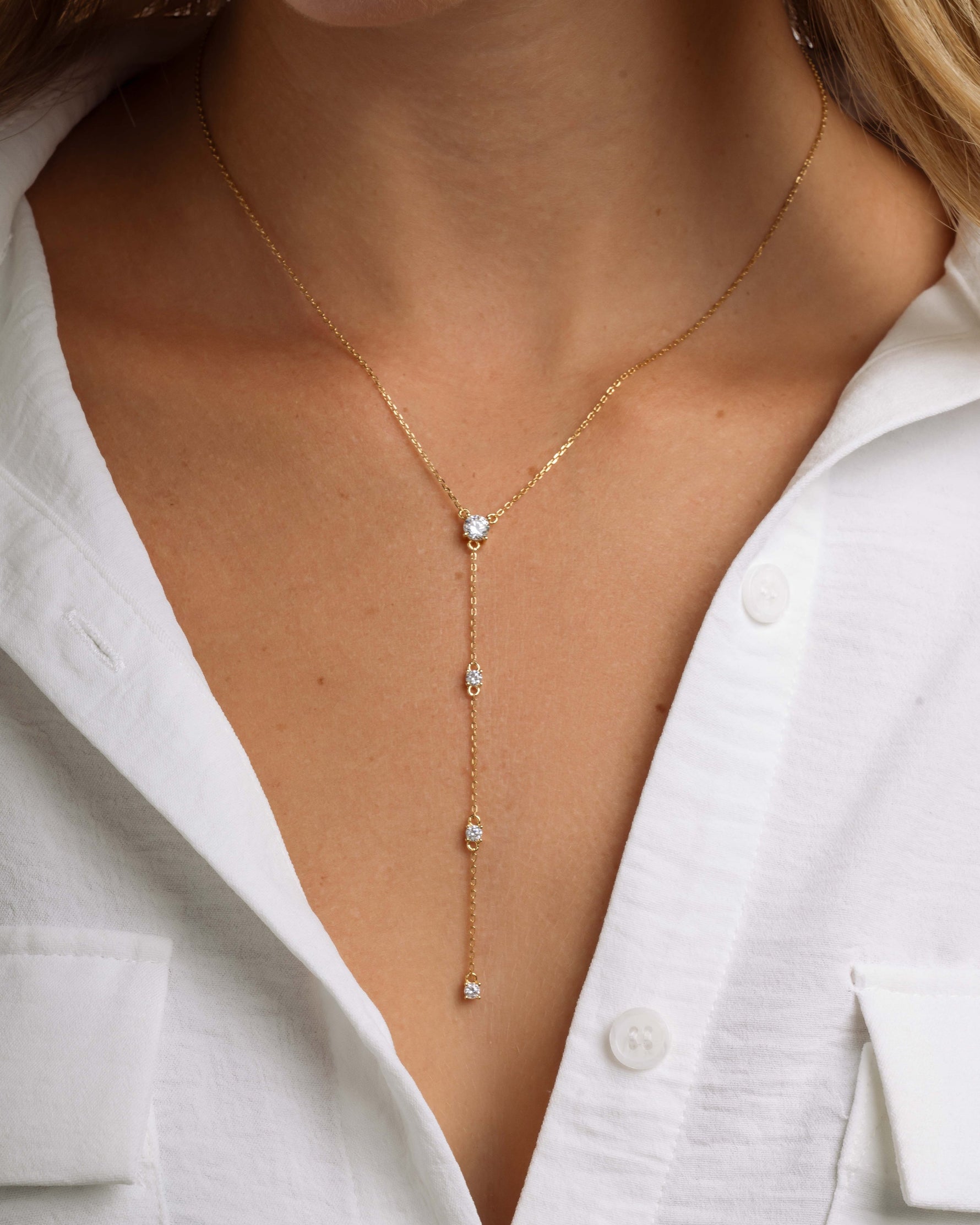 Gold lariat necklace on model