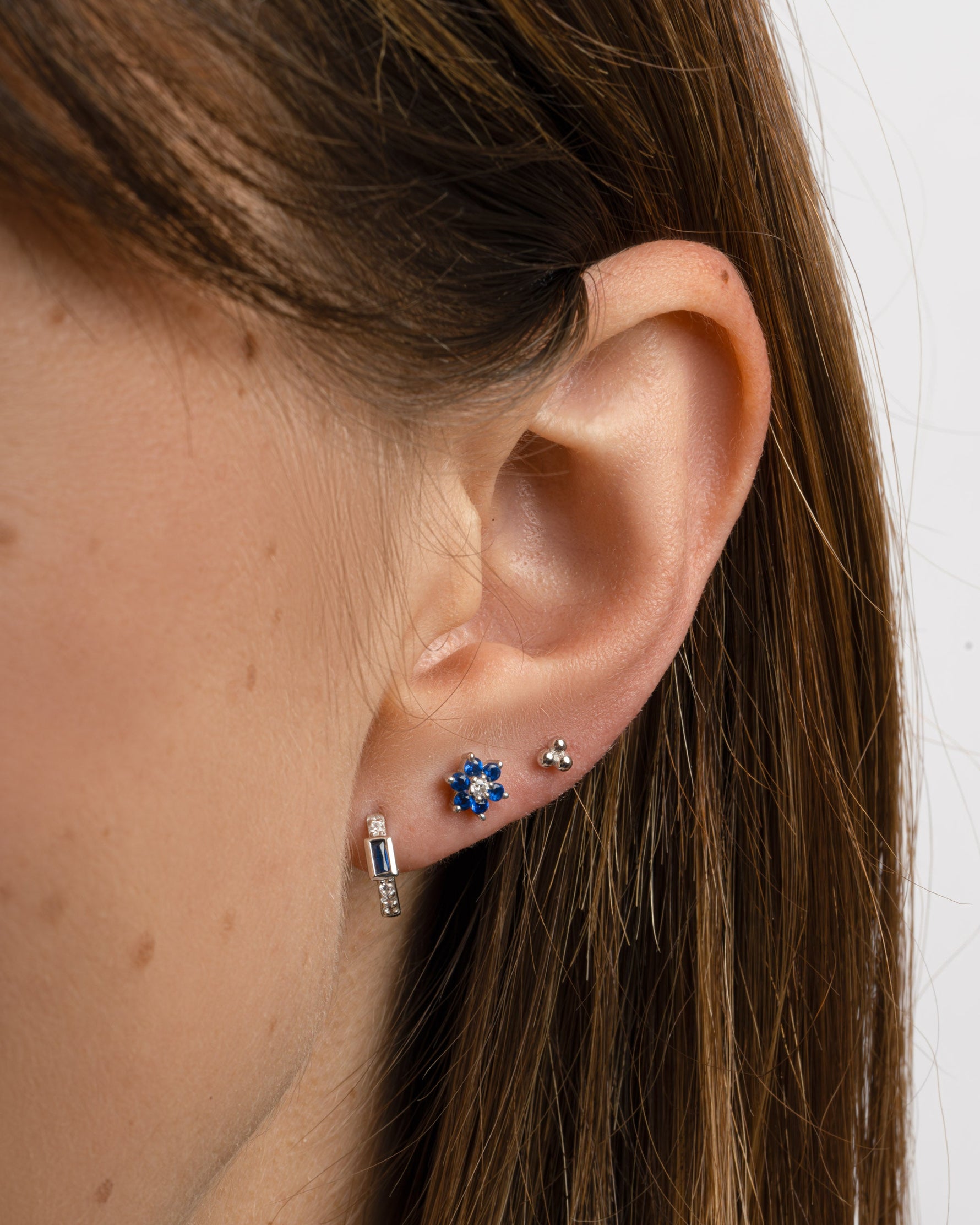Sapphire Baguette Huggie Earrings by Sami Jewels, silver earrings featuring rectangular-cut blue sapphires in a huggie style.