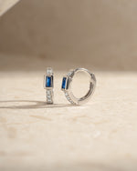 Sterling silver Sapphire Baguette Huggie Earrings with side view, showcasing sparkling blue sapphires and sleek hoop design.
