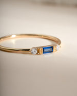 Gold sapphire baguette ring by Sami Jewels featuring a rectangular blue sapphire stone set in a sleek gold band