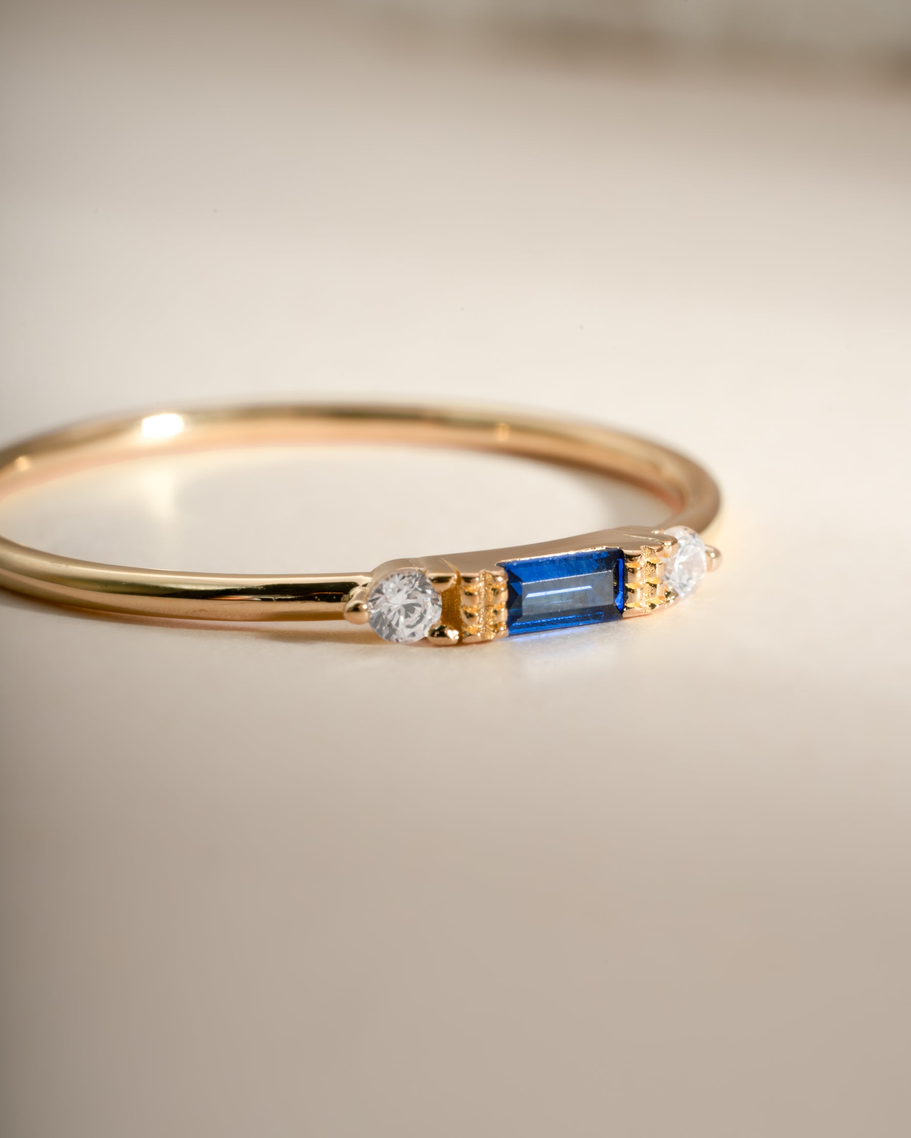 Gold sapphire baguette ring by Sami Jewels featuring a rectangular blue sapphire stone set in a sleek gold band