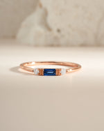 Sami Jewels sapphire baguette ring featuring a rose gold band with a rectangular blue sapphire gemstone.