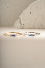 Sami Jewels sapphire baguette ring featuring sterling silver and gold accents, showcasing a sleek, rectangular blue sapphire gemstone.