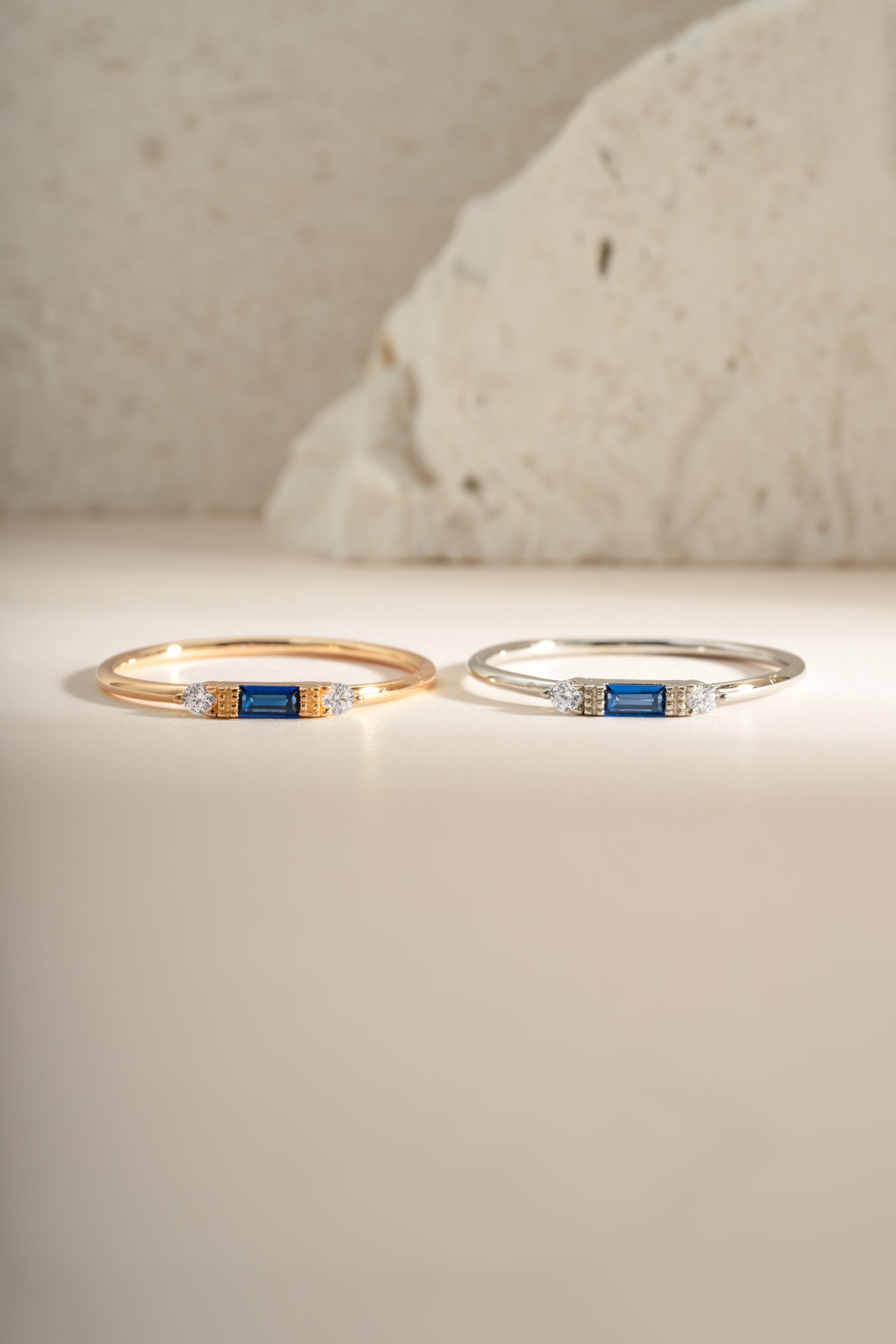 Sami Jewels sapphire baguette ring featuring sterling silver and gold accents, showcasing a sleek, rectangular blue sapphire gemstone.
